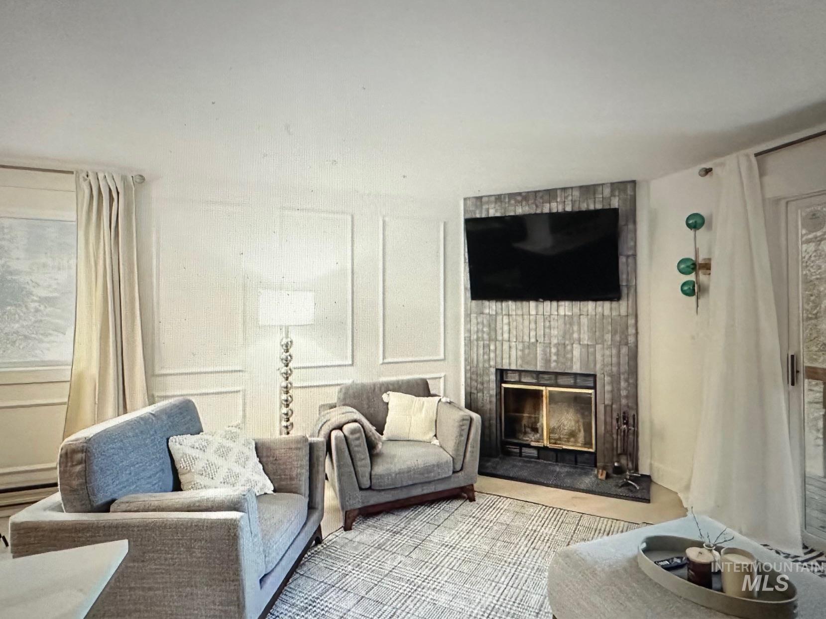 601 Hemlock Street, Unit 11 McCall, ID 83638 - Photo 4 of 19 Living area featuring a decorative wall and a tile fireplace