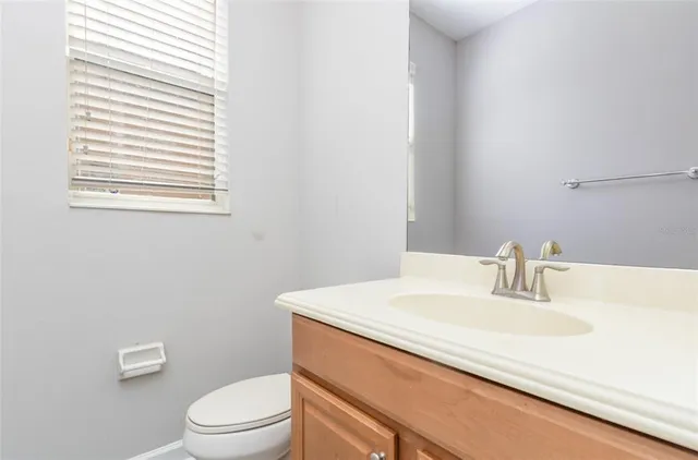 a bathroom with a sink a toilet and a window