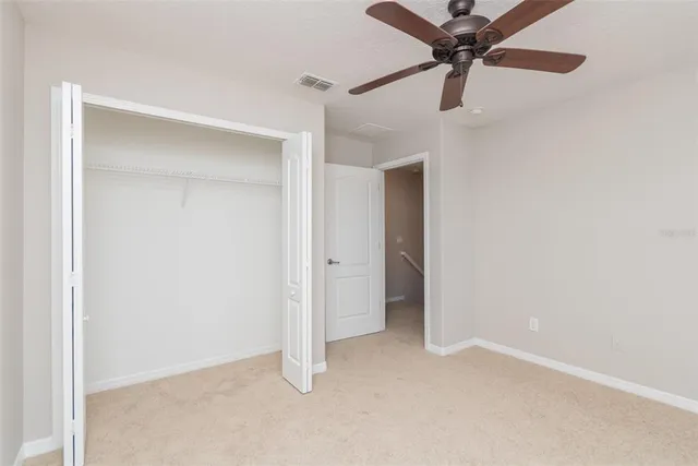 an empty room with a ceiling fan and a fan