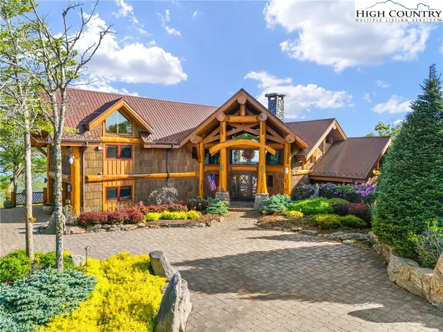 a front view of a building with garden and trees