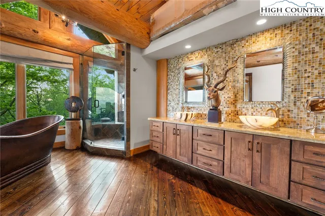 a spacious bathroom with double vanity a large window and a bathtub