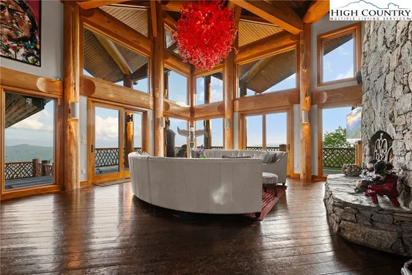 a living room with couches a coffee table and a large window with wooden floor