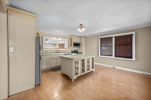 a view of kitchen with sink and refrigerator