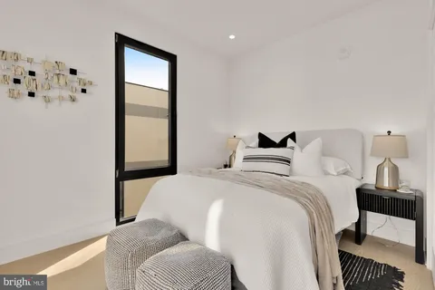 a view of a bedroom with wooden floor and windows