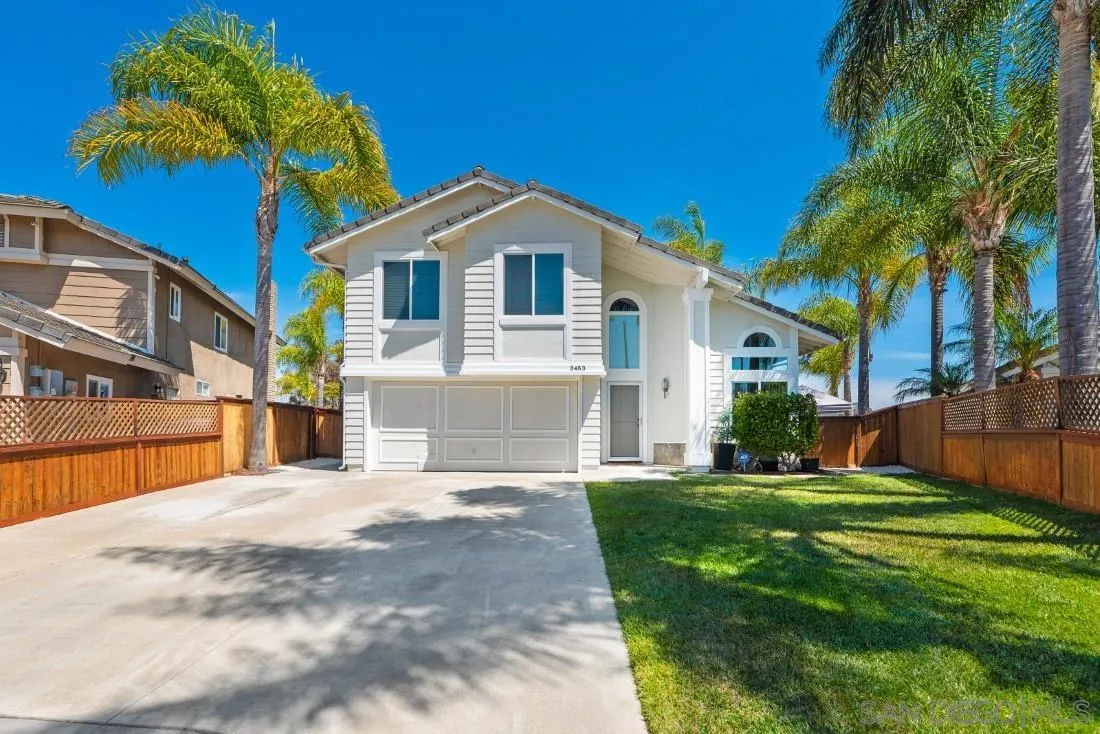 a front view of a house with a yard and palm trees
