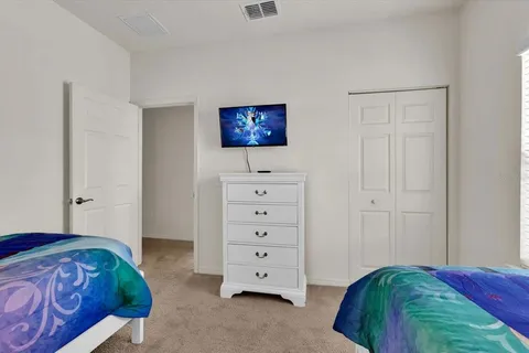 a view of a bedroom with bed and mirror