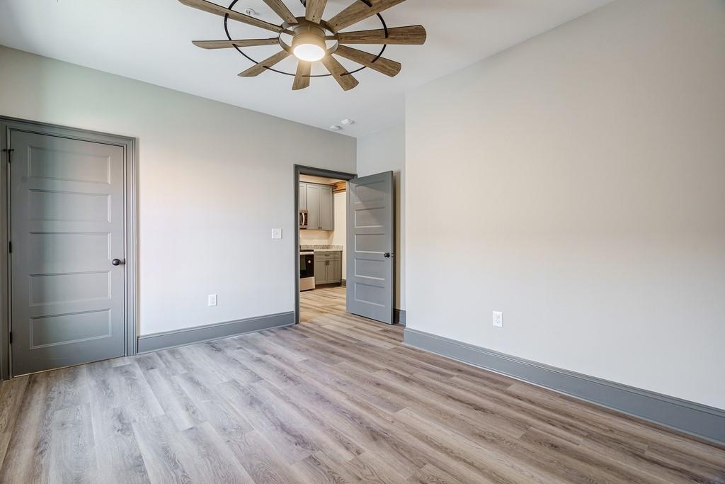 34 Depot Street, Unit 24 Hartwell, GA 30643 - Photo 17 of 22 an empty room with wooden floor chandelier fan and closet area