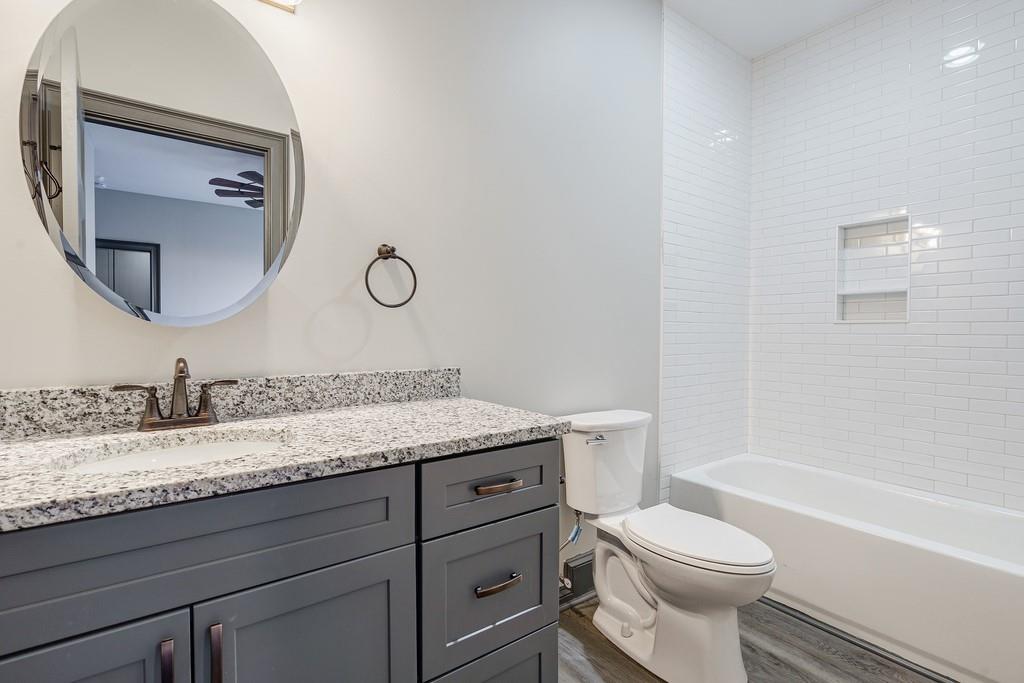 34 Depot Street, Unit 24 Hartwell, GA 30643 - Photo 18 of 22 a bathroom with a granite countertop toilet a sink and a mirror