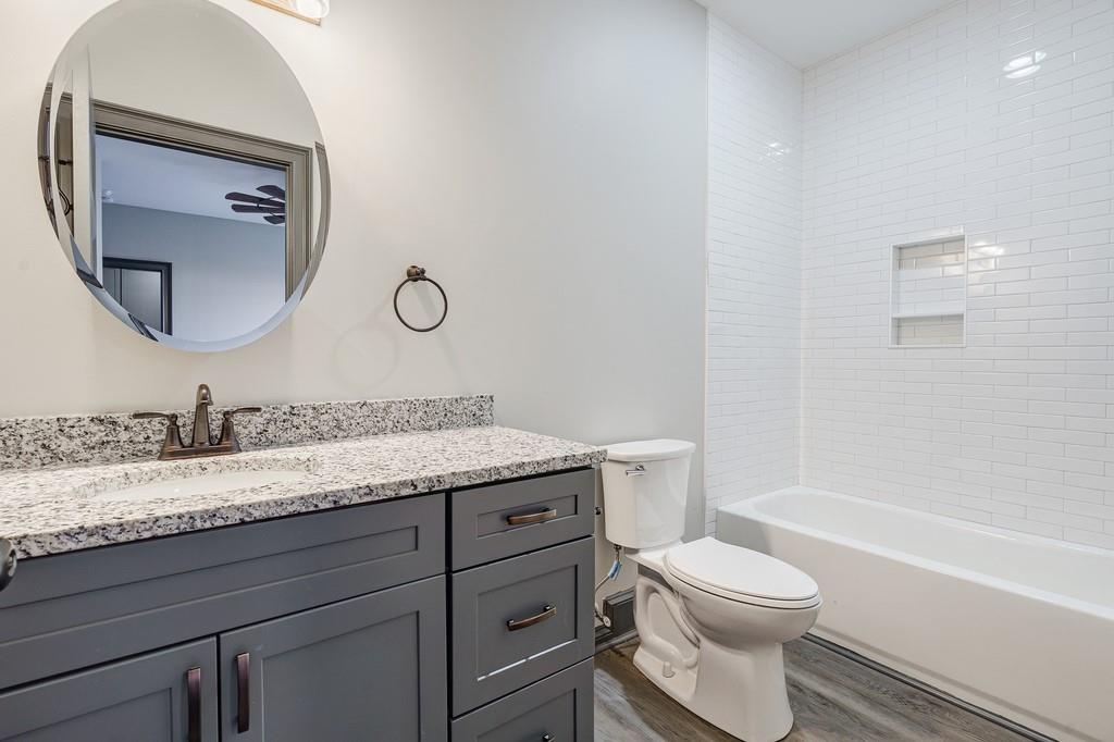 34 Depot Street, Unit 24 Hartwell, GA 30643 - Photo 19 of 22 a bathroom with a granite countertop toilet a sink and a mirror
