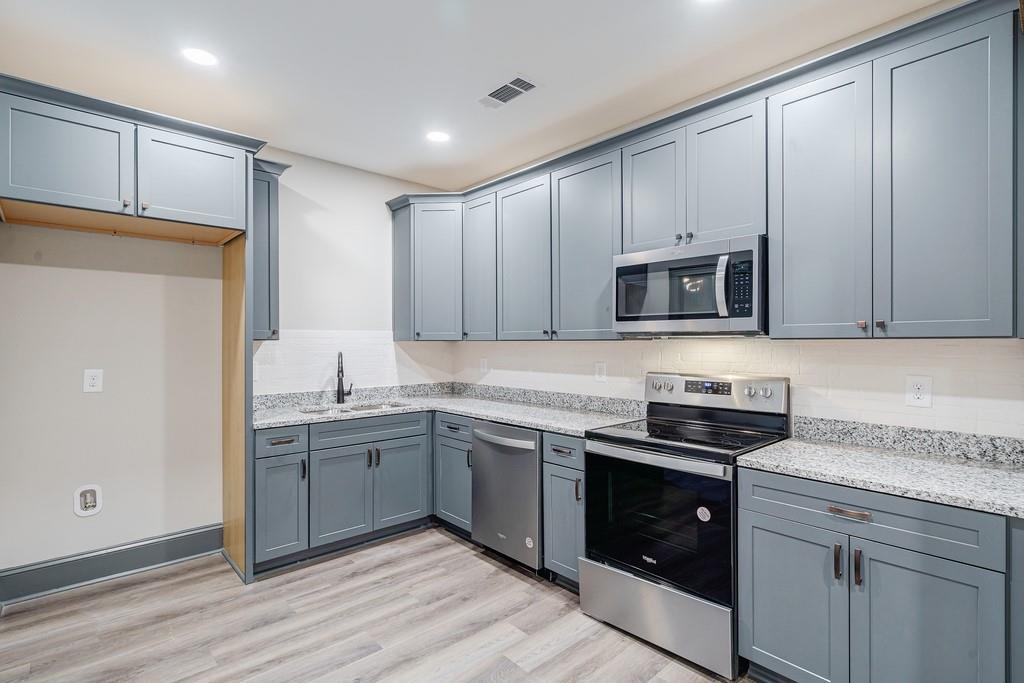 34 Depot Street, Unit 24 Hartwell, GA 30643 - Photo 10 of 22 a kitchen with stainless steel appliances granite countertop a stove a sink and a microwave