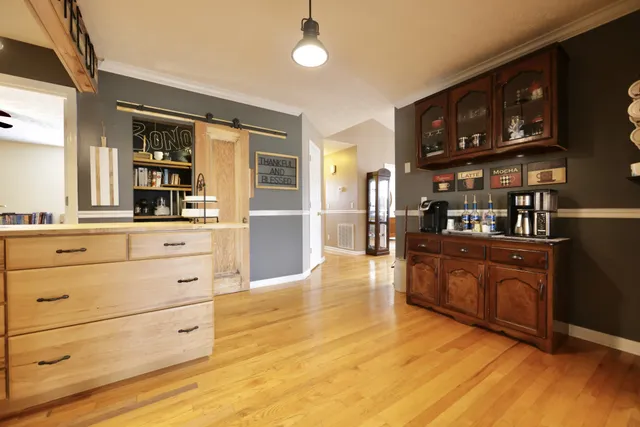 a view of kitchen with wooden floor and cabinets