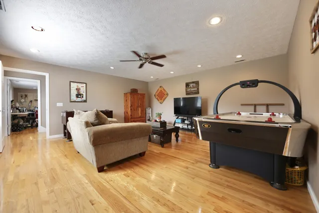 a living room with furniture a flat screen tv and kitchen view