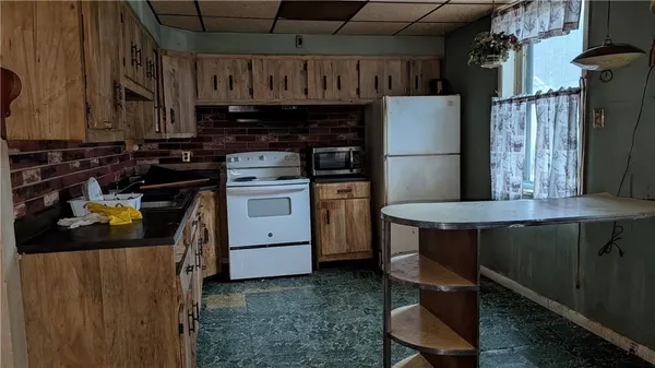 a kitchen with a stove a refrigerator and furniture