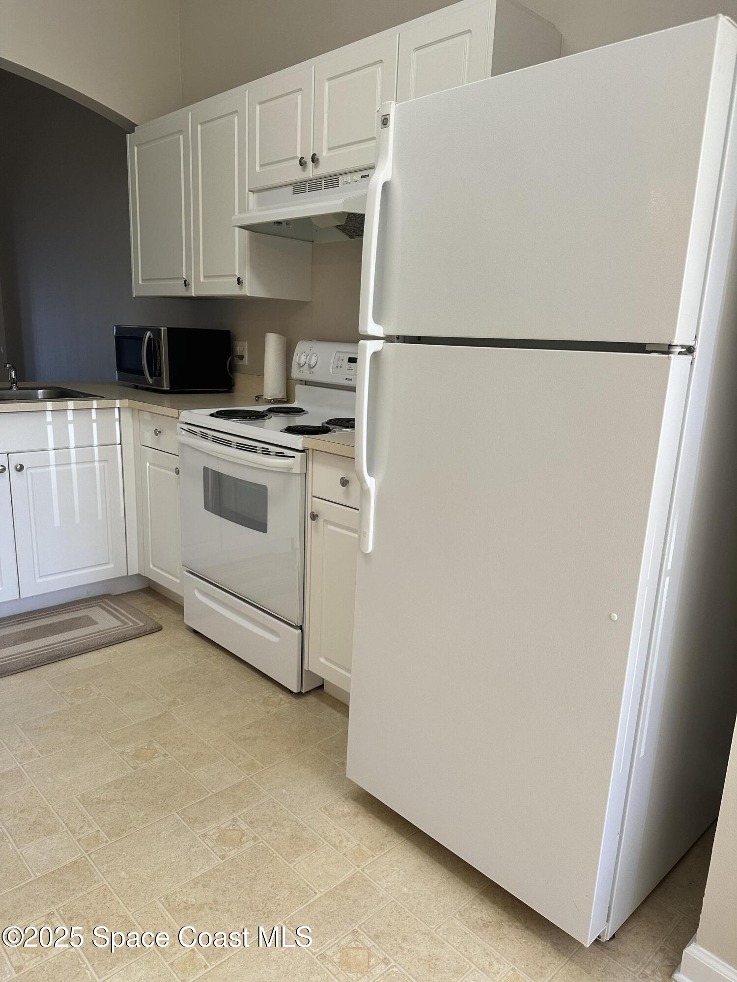975 Luminary Circle, Unit 103 Melbourne, FL 32901 - Photo 11 of 11 a white refrigerator freezer sitting in a kitchen