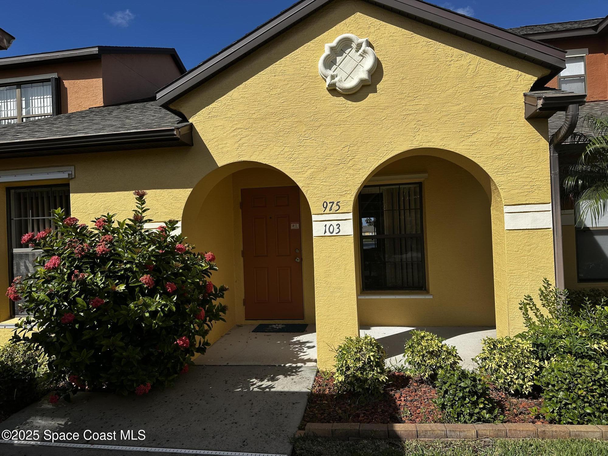 975 Luminary Circle, Unit 103 Melbourne, FL 32901 - Photo 2 of 11 a view of a house with a flower garden