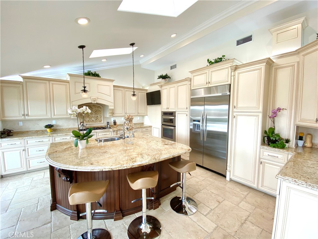 15 Curl Drive Corona del Mar, CA 92625 - Photo 5 of 26 a kitchen with a dining table chairs cabinets and stainless steel appliances