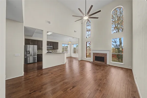 a view of a livingroom with furniture wooden floor and a kitchen