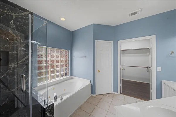 a spacious bathroom with a tub and shower