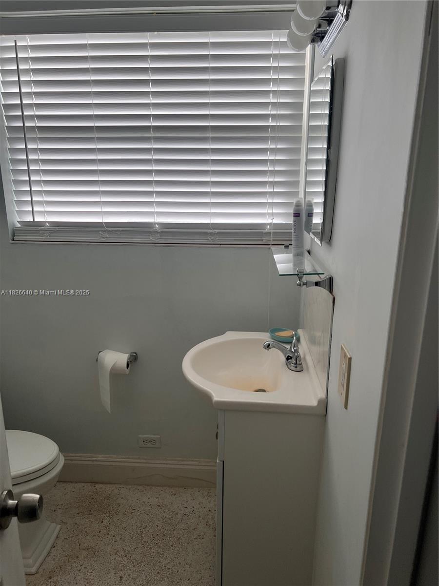 4475 Kirk Road Lake Worth, FL 33461 - Photo 19 of 26 a bathroom with a sink a toilet and a mirror