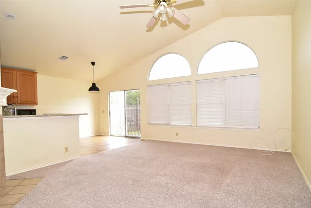 an empty room with a fireplace and windows
