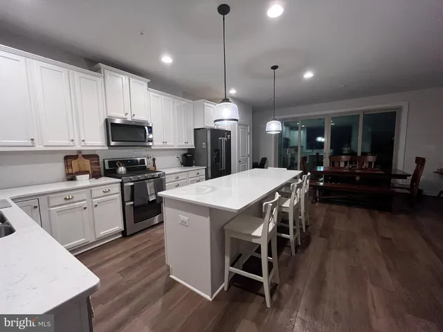 a kitchen with a dining table chairs sink and cabinets