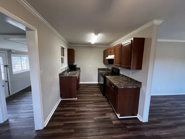 a view of a kitchen counter space a sink and wooden floor