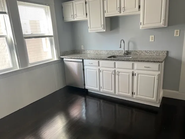 a kitchen with stainless steel appliances granite countertop white cabinets and a granite counter tops