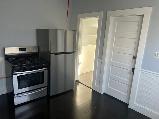 a kitchen with a refrigerator and a stove top oven