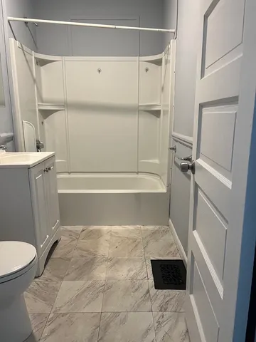 a bathroom with a toilet and a shower