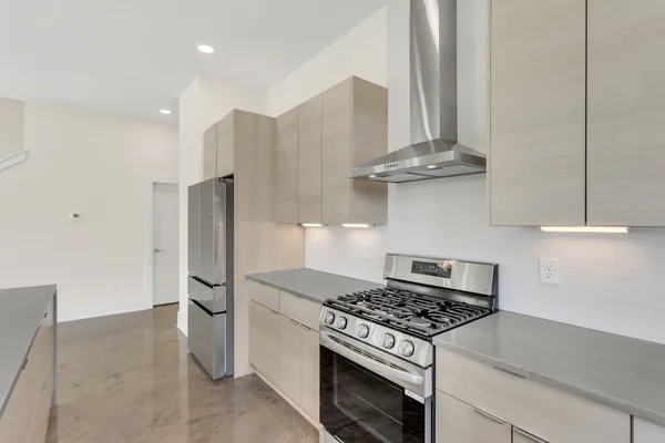 a kitchen with stainless steel appliances granite countertop a stove and a refrigerator