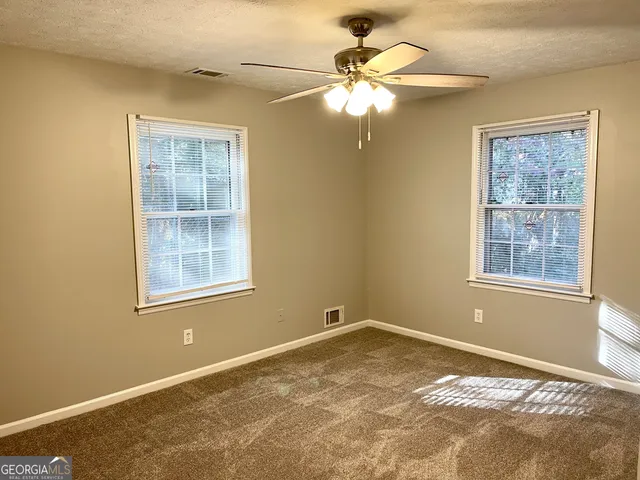 a view of a livingroom with a chandelier fan and a window