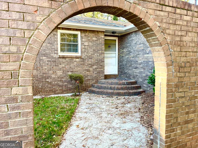 a view of a brick house with plants