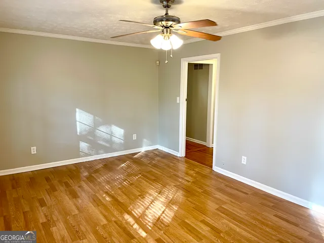a view of empty room with wooden floor