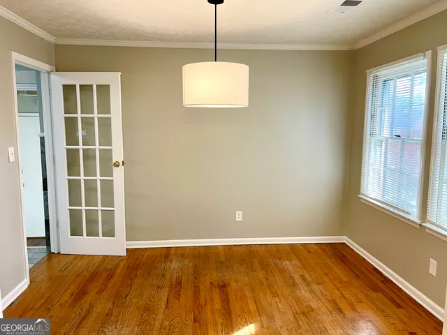 a view of an empty room with windows and chandelier
