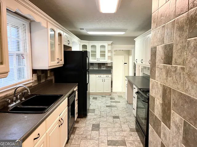 a kitchen with granite countertop a refrigerator and a sink