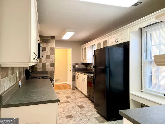 a kitchen with stainless steel appliances granite countertop a refrigerator a stove and a sink