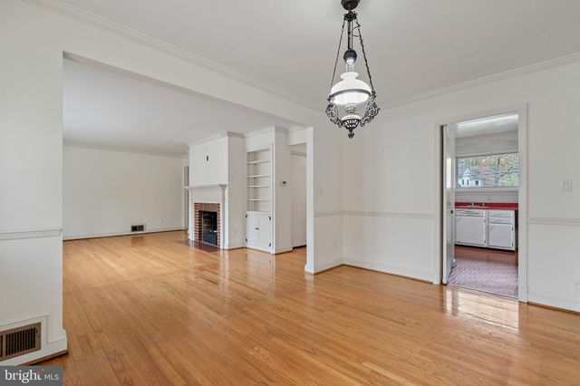 a view of a room with wooden floor and a ceiling fan