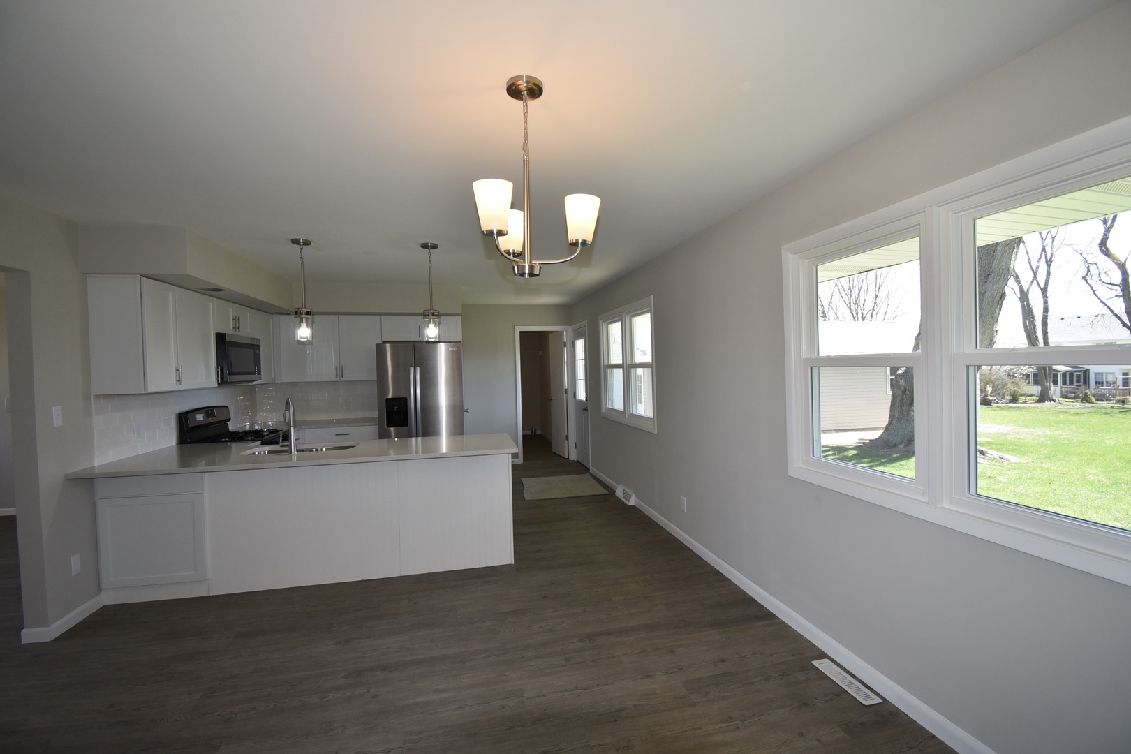 413 East Northtown Road North Normal, IL 61761 - Photo 10 of 20 a view of a kitchen with a sink wooden cabinets and a window