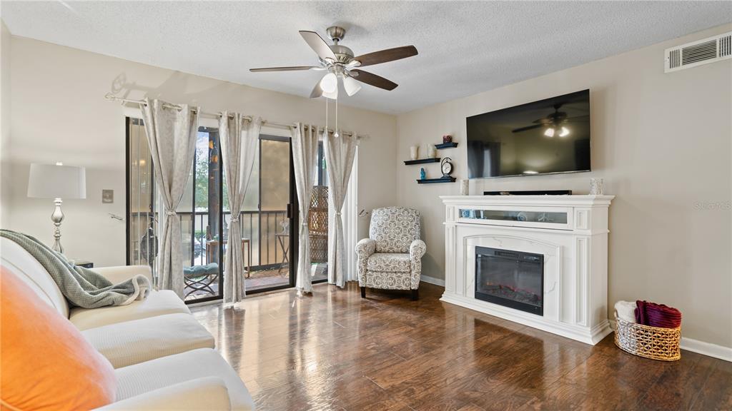 8203 Sun Spring Circle, Unit 12 Orlando, FL 32825 - Photo 12 of 38 a living room with furniture a flat screen tv and a fireplace