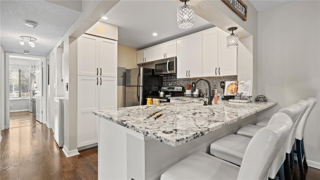 8203 Sun Spring Circle, Unit 12 Orlando, FL 32825 - Photo 26 of 38 a kitchen with stainless steel appliances granite countertop a sink refrigerator and cabinets