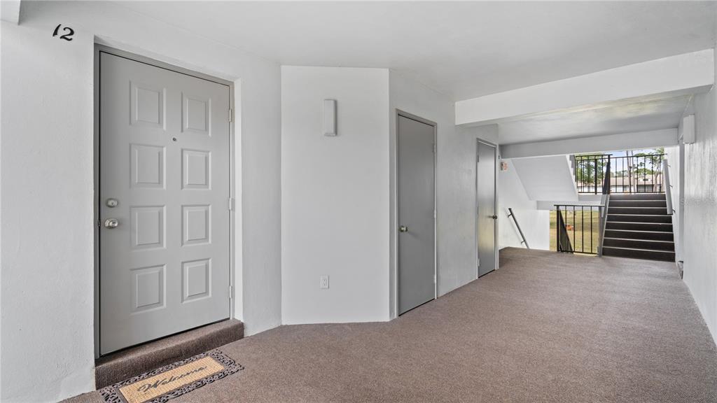 8203 Sun Spring Circle, Unit 12 Orlando, FL 32825 - Photo 33 of 38 a view of a livingroom with a chair and front door
