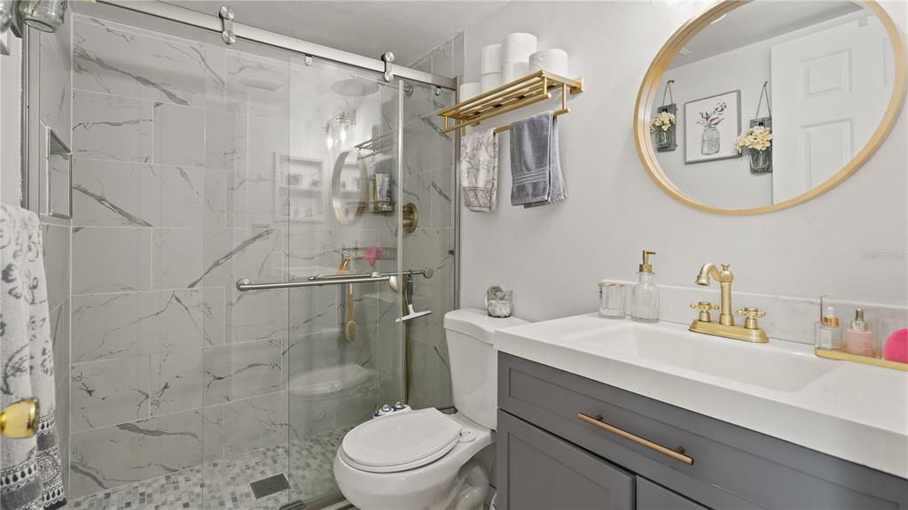 8203 Sun Spring Circle, Unit 12 Orlando, FL 32825 - Photo 7 of 38 a bathroom with a sink a mirror a toilet and a shower