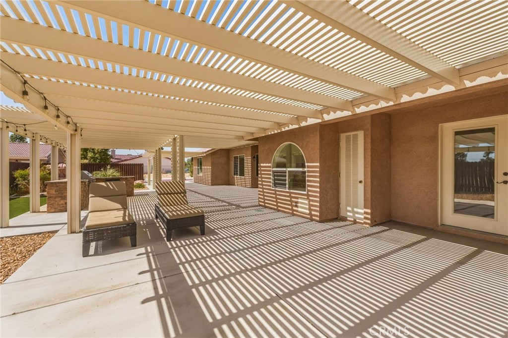 19501 Kinai Road Apple Valley, CA 92307 - Photo 41 of 49 a view of a patio with table and chairs with wooden floor
