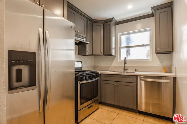 a kitchen with stainless steel appliances granite countertop a stove a refrigerator and a sink