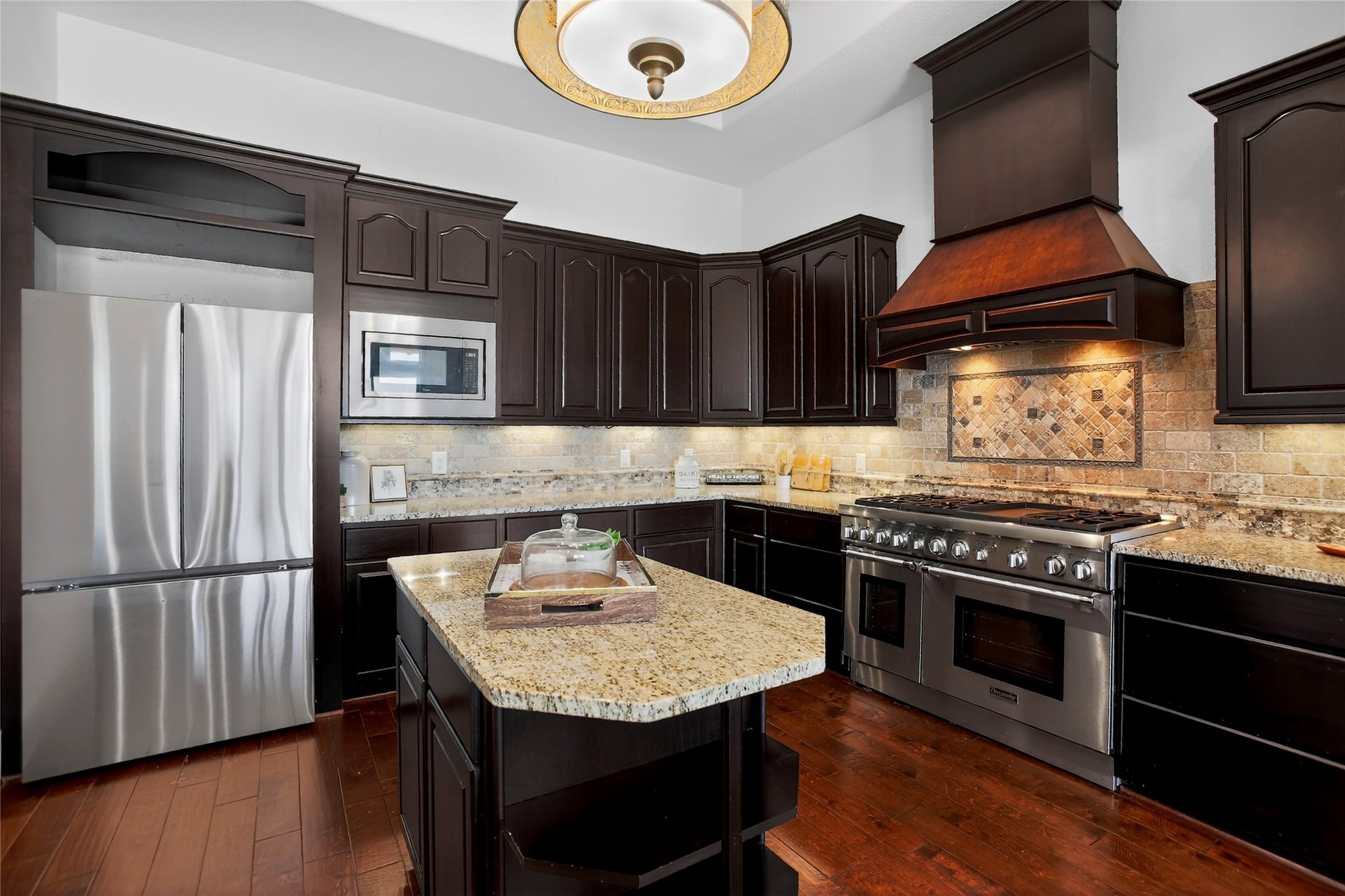 12349 Tramonto Conroe, TX 77304 - Photo 15 of 50 a kitchen with stainless steel appliances granite countertop a stove a refrigerator and a microwave