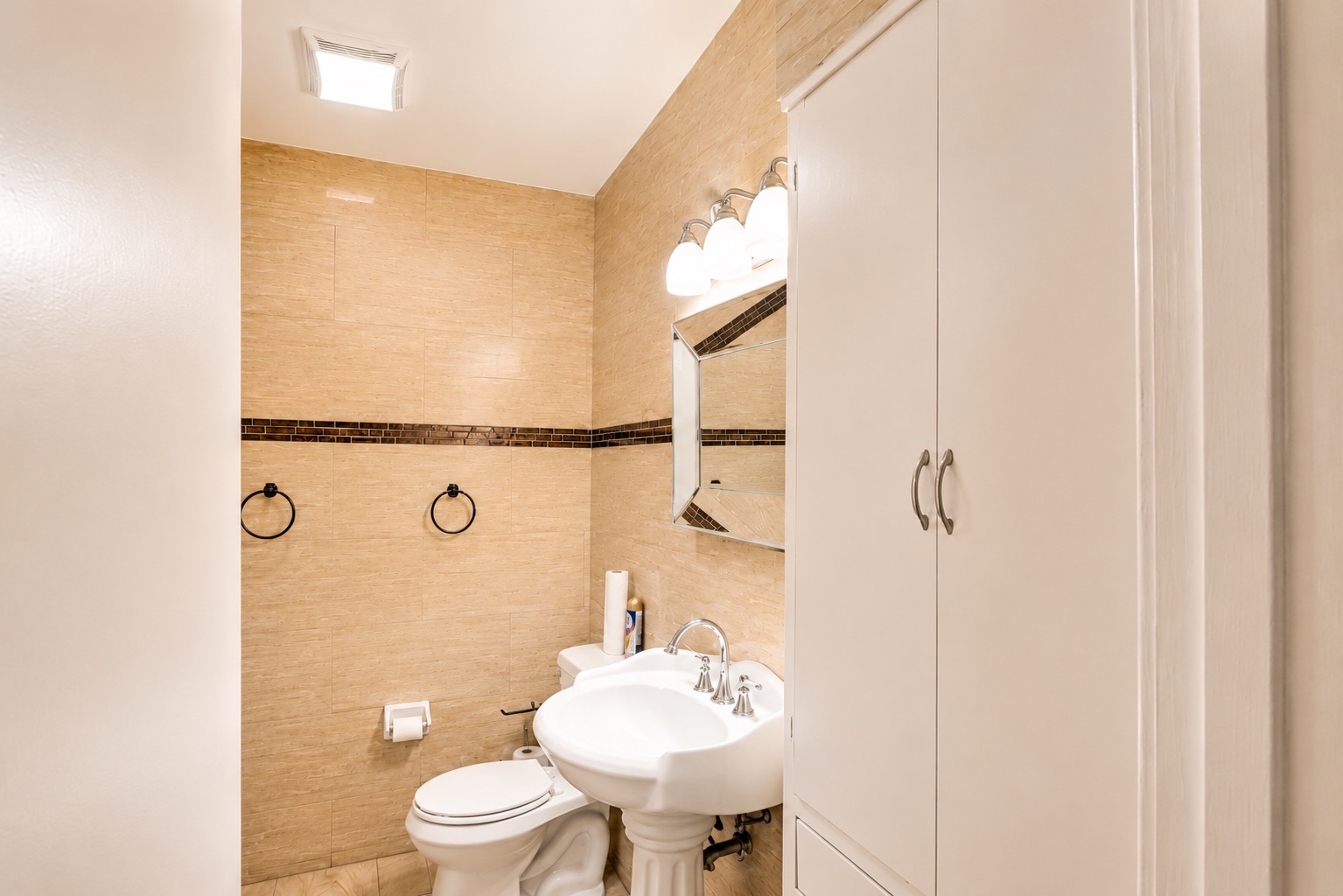 1508 Walnut Street Georgetown, TX 78626 - Photo 31 of 37 A well-lit powder room showcasing neutral-toned tile walls and pedestal sink.