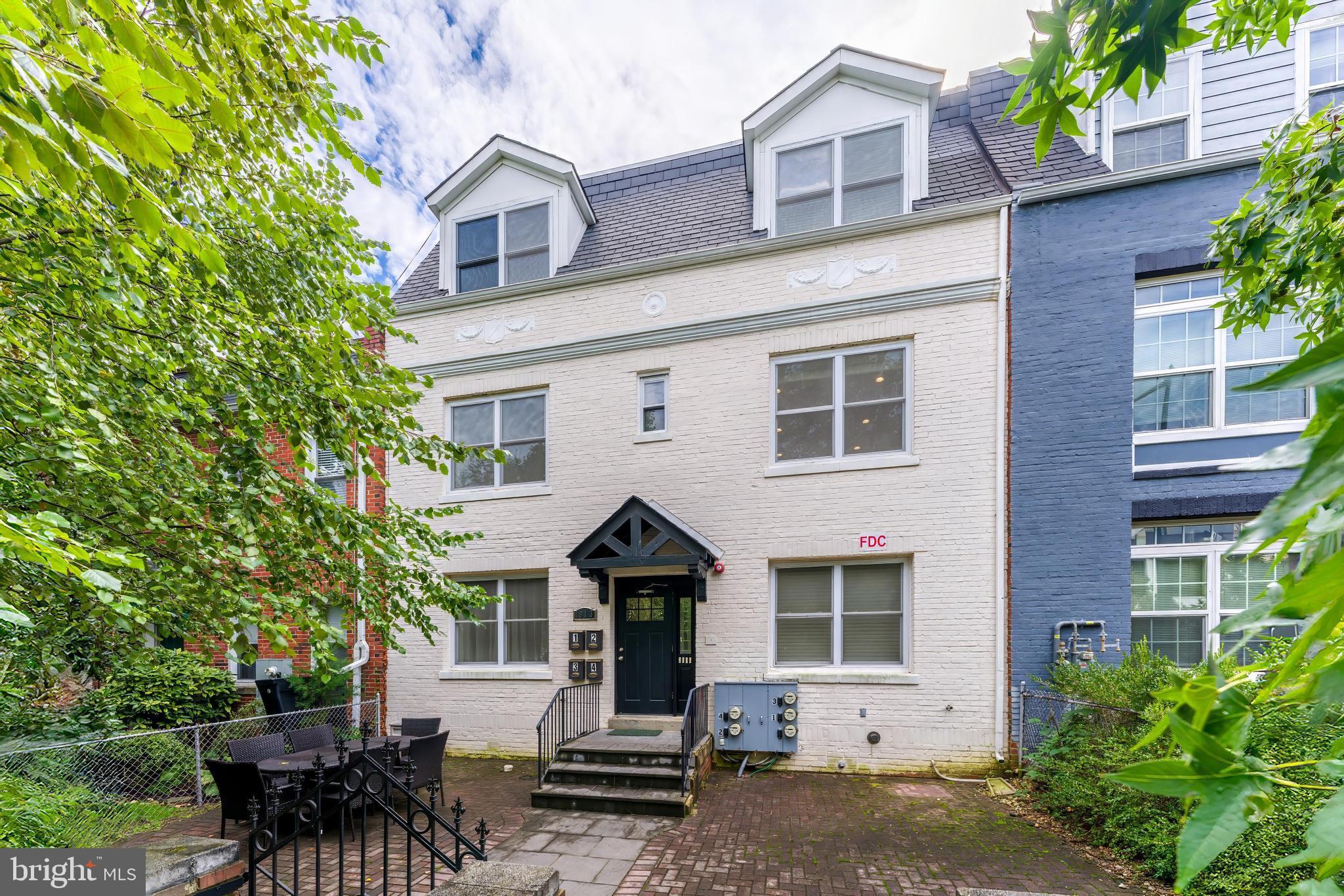 front view of house with a bench and potted plants