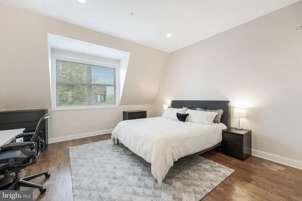 a bedroom with a bed window and a desk