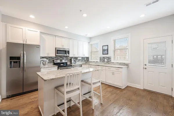 a kitchen with white cabinets and stainless steel appliances