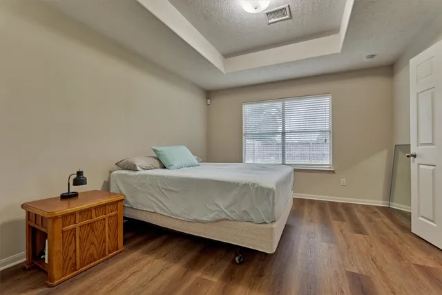 a bedroom with a bed and wooden floor